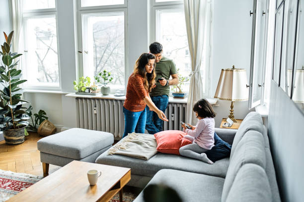 istock Father and daughter using mobile phones at home 1257915665