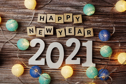Feliz Año Nuevo 2021 decorar con bola de coton LED sobre fondo de madera photo