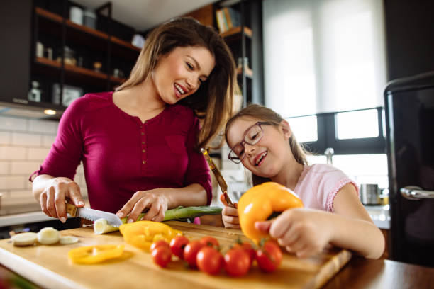 istock Mother and daughter cutting vegetable in the kitchen 1257915758