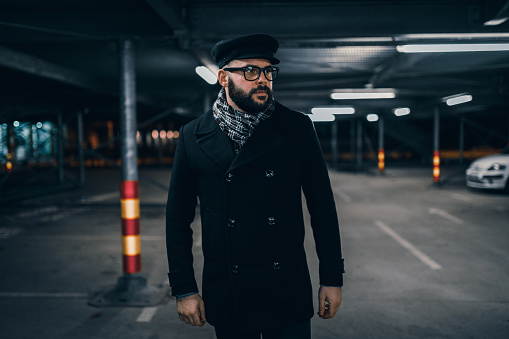 Handsome young man walking in the parking lot in the night