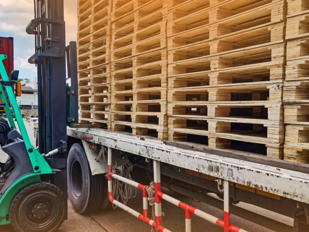istock Worker driving forklift to loading and unloading wooden pallets from truck to warehouse cargo storage, shipment in logistics and transportation industrial, wood pallets stack 1257917587