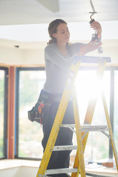 istock female electrician installing downlights 1257918396