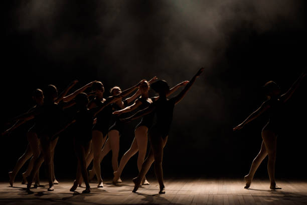 istock Young ballerinas rehearsing in the ballet class. They perform different choreographic exercises and stand in different positions. 1257918426