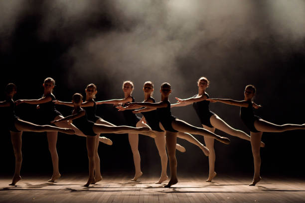 istock Young ballerinas rehearsing in the ballet class. They perform different choreographic exercises and stand in different positions. 1257918531