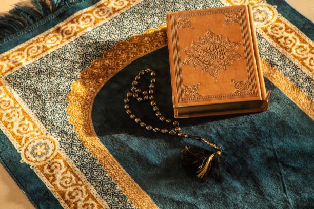 istock prayer beads and Noble Koran on Praying Carpet with Natural Light 1257918732