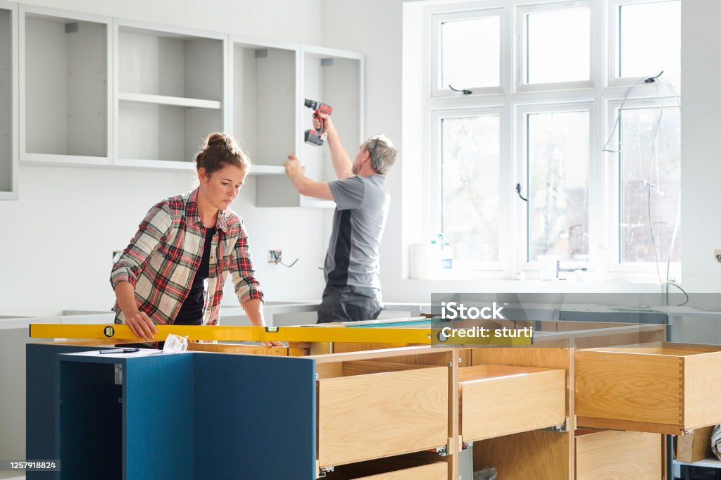 kitchen fitters a female kitchen fitting cupboards for worktop Home Improvement Stock Photo