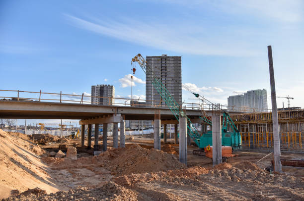 istock Roundabout and traffic bridge construction. Construction highway ramps and bridgeworks. Crane for formwork on bridge project works. Road work on traffic highway, road intersection junction and freeway 1257922528