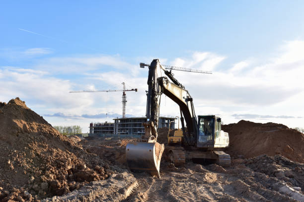 istock Excavator working at construction site on earthworks. Backhoe digging building foundation. Paving out sewer line. Heavy machinery for road work, excavating, loading, lifting and hauling of cargo 1257923511