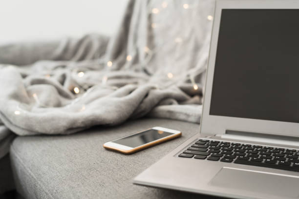 istock Laptop computer and smartphone on gray sofa bed. Work from home concept 1257923662