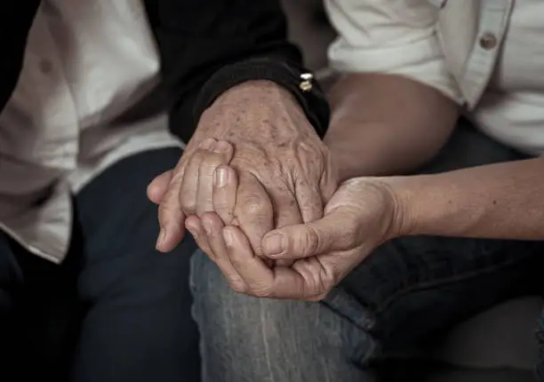 Mother and daughter hands holding together in love and support after loosing love ones amid coronavirus outbreak