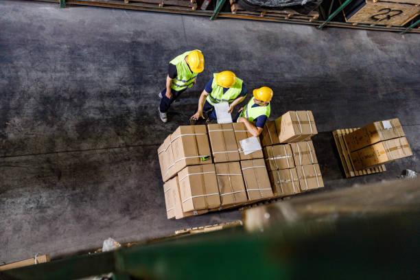 istock Above view of manual workers working with packages in distribution warehouse. 1257925921