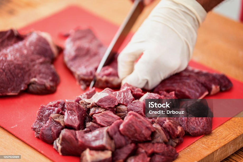 Game animal meat cut on cutting board, close up, selective focus Game meat cut into cube shaped chunks, close up, selective focus Horsemeat Stock Photo