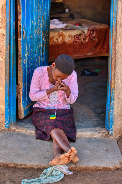 donna africana tabacco da fiuto di fronte alla sua casa - dipping tobacco foto e immagini stock