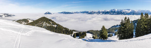 incredibile vista panoramica da snow mountain alla snowy mountain range sopra lo strato di nuvole nebbioso. mare di nuvole. rangiswangerhorn, allgau, baviera, germania. - allgau bavaria mountain horizon foto e immagini stock