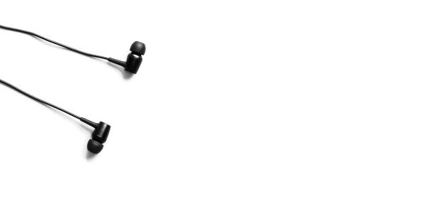 istock Black earphones lying on the white background. Modern music concept. Audio technology. 1257929585