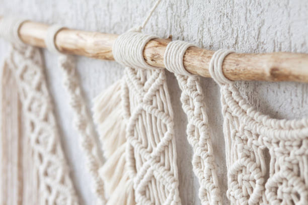 Close-up of hand made macrame texture pattern.  ECO friendly modern knitting DIY natural decoration concept  in the interior. Flat lay. Handmade macrame 100% cotton. Details close up. Female hobby.
