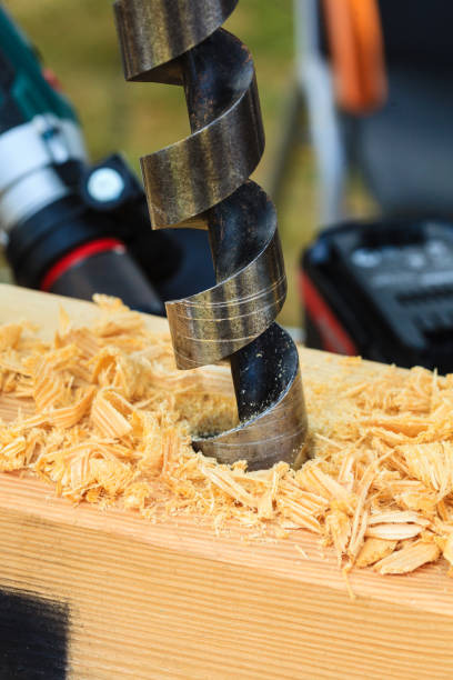 istock Metal machine drilling in wooden board 1257929885