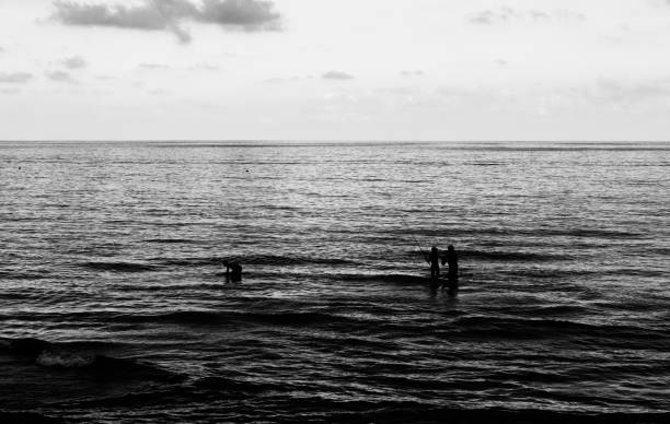 istock People by the sea at sunset 1257930086