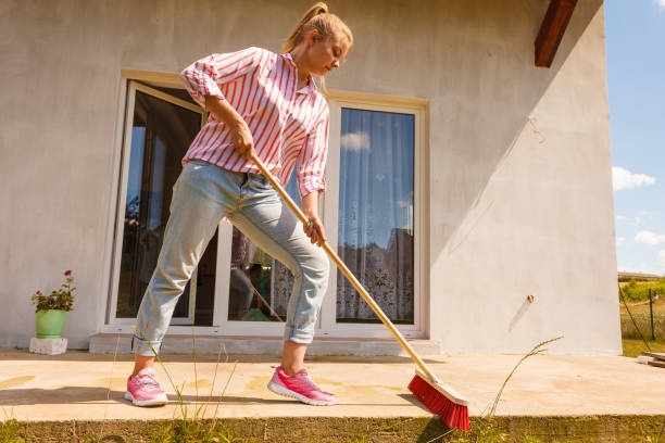 istock Woman cleaning patio using brush broom 1257930877