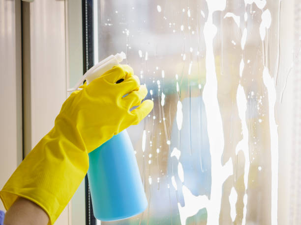 istock Gloved hand cleaning window rag and spray 1257930951