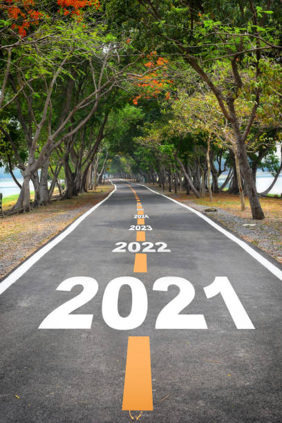 istock Tree tunnel with 2021 to 2026 on asphalt road surface 1257932373