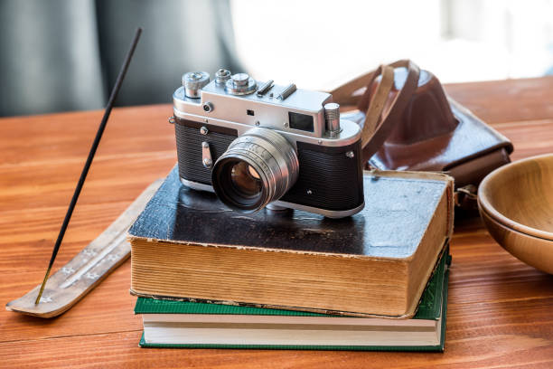istock Old vintage camera and books at old wooden table 1257933734