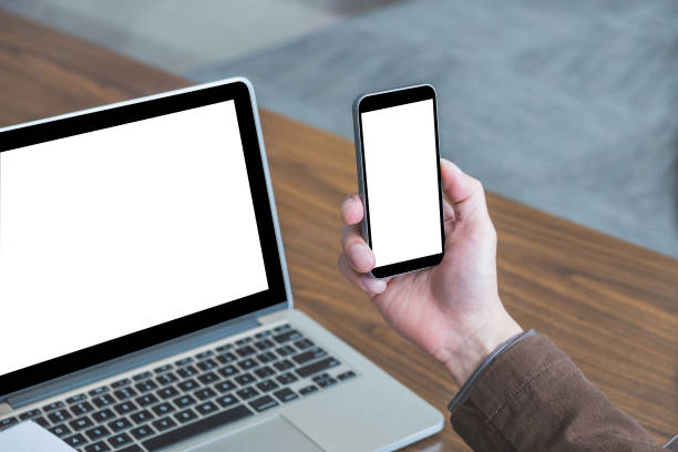 istock Mock up image of male hand holding blank screen smart phone with blank screen computer background 1257936666