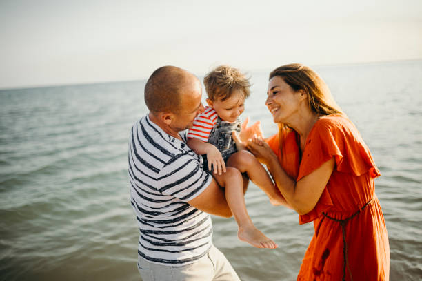 istock Family enjoys the sunset on the beach 1257938334
