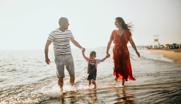 istock Family enjoys the sunset on the beach 1257938364