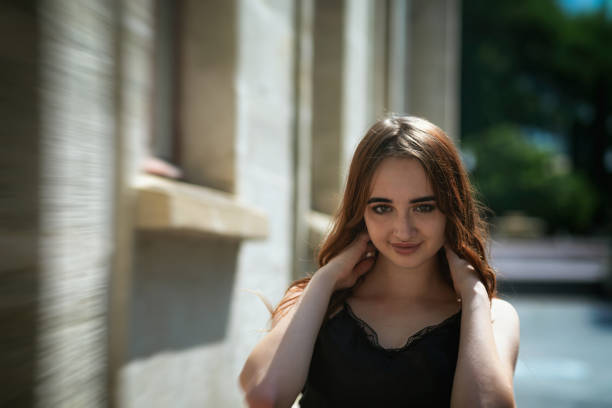 Charming red-haired teen girl in the Park posing for the camera