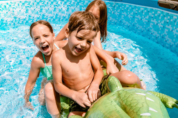 istock Kids playing in swimming pool 1257943021