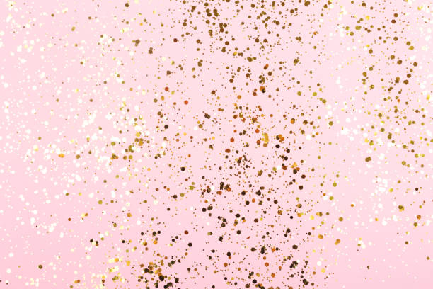 istock Falling gold color confetti on gentle pink background. 1257944687