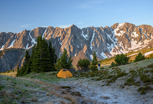 British Columbia, Canada - July 6, 2020: A tent pitched in a mountain meadow at sunrise in the Coast Mountains, British Columbia, Canada.