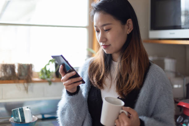 istock young asian woman using laptop and making phone call working at home during COVID-19 1257947190