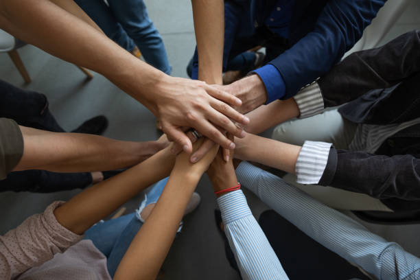 istock Close up mixed race business people putting hands together support. 1257948536