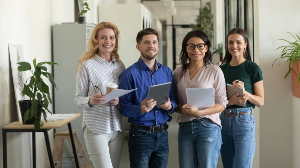 istock Portrait of standing smiling team with documents looking at camera. 1257948574