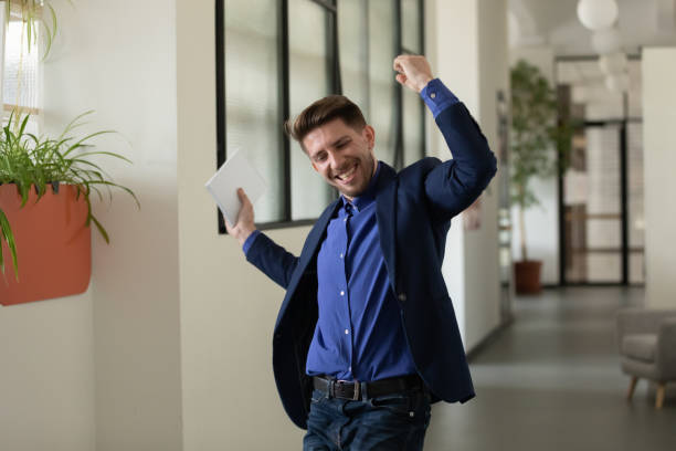 istock Emotional happy businessman celebrating successful project presentation in office. 1257948584