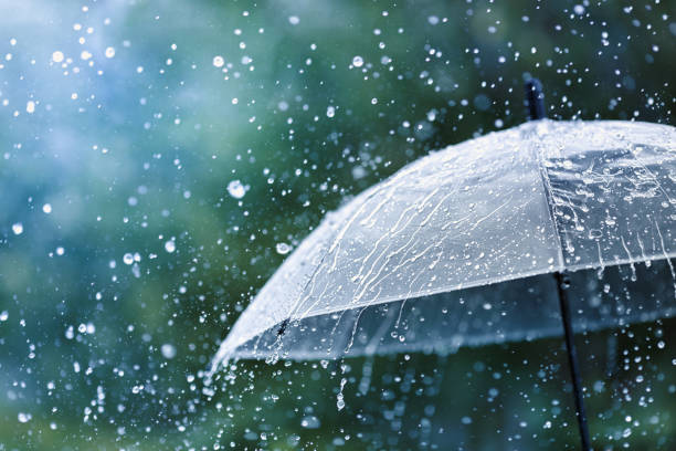ombrello trasparente sotto la pioggia contro gocce d'acqua splash sfondo. concetto di tempo piovoso. - pioggia foto e immagini stock