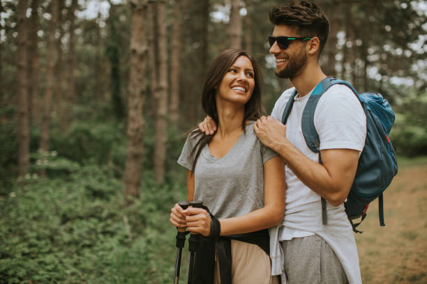 istock Smiling young couple walking with backpacks in the forest 1257953278