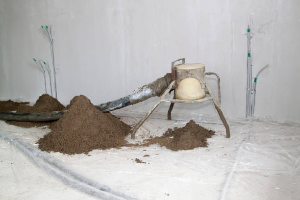 istock Sand and cement floor screed. Construction site - machine floor screed and electic wires. 1257954281