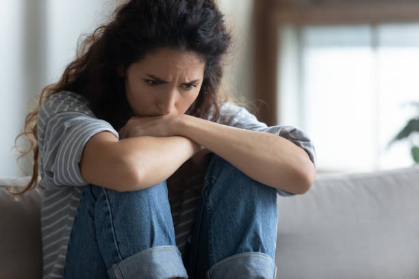 istock Close up depressed young woman sitting alone, thinking about problems 1257955501