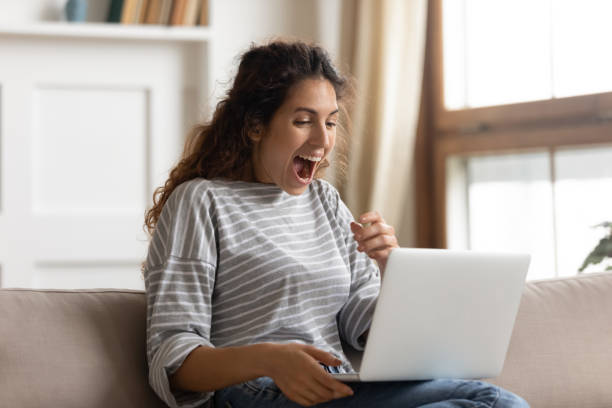 istock Amazed woman with open mouth looking at laptop screen 1257955554