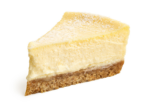 Slice of New York style cheesecake isolated on white.
