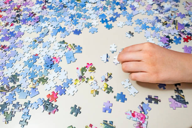 istock close up hand holding puzzle pieces 1257962095