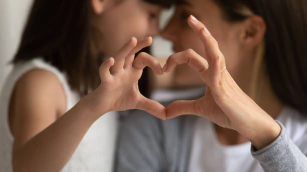 istock Young mother and little daughter posing making heart gesture 1257964391