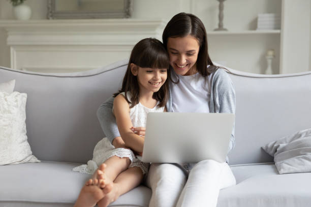 istock Smiling young mom and little daughter relax using laptop 1257964413