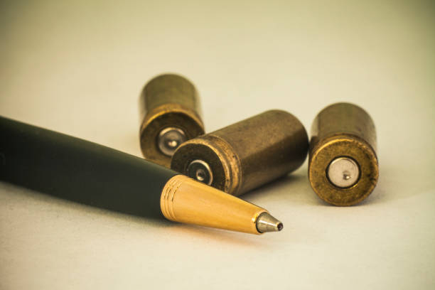 un bolígrafo y balas símbolo de la prensa en la guerra. guerras híbridas - war globe symbols of peace weapon fotografías e imágenes de stock