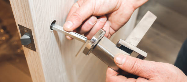 istock Man is installing the doors handle. Repair works. Maintenance in the apartment. 1257967855