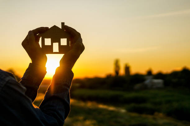 istock house in hands over beautiful sunset 1257970527