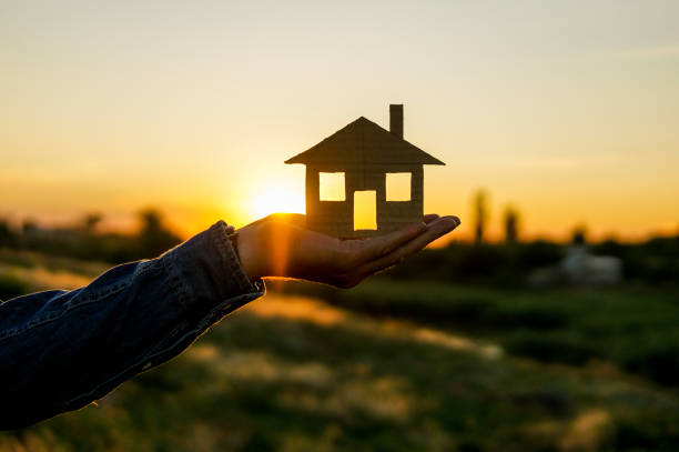 istock house in hands over beautiful sunset 1257970528